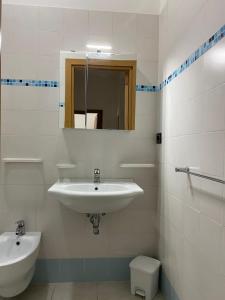 bagno bianco con lavandino e servizi igienici di Appartamenti Vacanze Vista mare ad Alba Adriatica