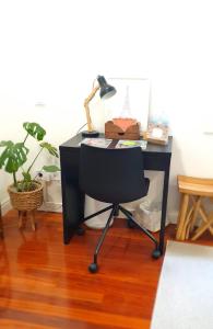 a black desk with a chair and a lamp at Acogedor y luminoso apartamento en Neguri in Getxo