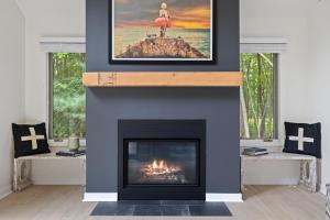 una sala de estar con chimenea y una foto encima. en The Coyote, en Saugatuck