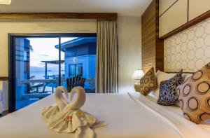 a bedroom with a bed with two swans towels at Neptune's Villa in Haad Rin