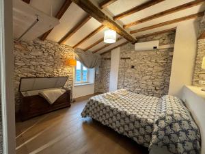 1 dormitorio con cama y pared de piedra en Villa Patrizia Pietrasanta en Pietrasanta