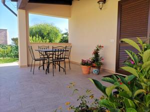 a patio with four chairs and a table and some plants at Villa Azzurra in Lampedusa