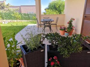 a patio with a table and some potted plants at Villa Azzurra in Lampedusa