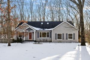 a white house in the snow with trees at The High Life in New Buffalo