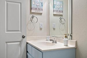 ein Badezimmer mit Waschbecken und Spiegel in der Unterkunft Deep Blue Yonder - Ping-pong! Bikes! Games! Cute and cozy 3-bed, 2-bath home in the heart of Crystal Beach! in Crystal Beach + 21 Fotos