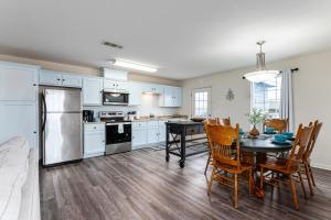eine Küche mit einem Esstisch und eine Küche mit weißen Schränken in der Unterkunft Deep Blue Yonder - Ping-pong! Bikes! Games! Cute and cozy 3-bed, 2-bath home in the heart of Crystal Beach! in Crystal Beach