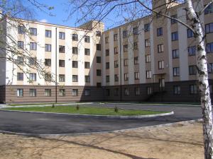 a large building with a street in front of it at Friendly House in Vyshneve