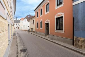 une rue vide avec des bâtiments orange et blancs dans l'établissement Wachau Ruhepol / 45m² / Idyllisch mit Gartenterrasse, à Mautern