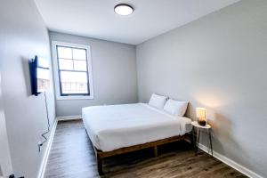 a white bedroom with a bed and a window at Gin Fizz in Port Saint Joe