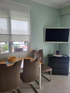 Pokój ze stołem i krzesłami oraz telewizorem z płaskim ekranem w obiekcie Квартира Халкидики Флогита / Ferienwohnung Chalkidiki Griechenland w mieście Flogita