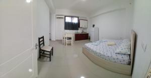 Un dormitorio blanco con una cama y una cocina. en Ajla Apartment, en Ksamil 1 foto más