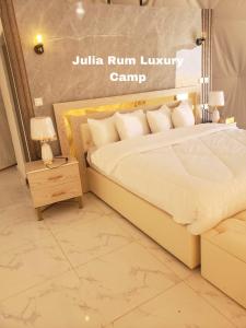 - une chambre avec un lit et une table avec une lampe dans l'établissement Julia Rum Luxury Camp, à Wadi Rum