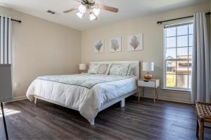 ein Schlafzimmer mit einem Bett und einem Deckenventilator in der Unterkunft Deep Blue Yonder - Ping-pong! Bikes! Games! Cute and cozy 3-bed, 2-bath home in the heart of Crystal Beach! in Crystal Beach