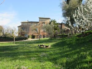 una persona sdraiata sull'erba di fronte a una casa di Agriturismo La Torretta - apt 4rooms with exclusive pool a Siena