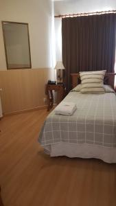 Schlafzimmer mit einem Bett und einem Tisch mit einem Spiegel in der Unterkunft Hotel Azul Junin in Junín
