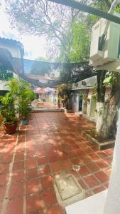 een binnenplaats van rode bakstenen met bomen en gebouwen bij House Marfito Airport in Cartagena