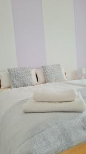 a white bed with two pillows on top of it at Oaza L in Majar