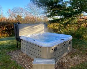 a hot tub sitting in the grass in the yard at The White Owl in Harbert