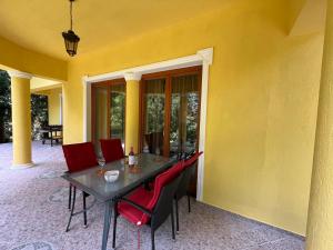 mesa de comedor con sillas rojas y pared amarilla en Klára Villa, en Balatonboglár