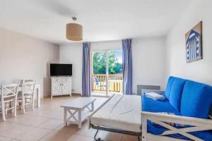 a living room with a blue couch and a table at B08 1er etage La Ferme de Deauville 1 ch SOZEN C in Saint-Arnoult