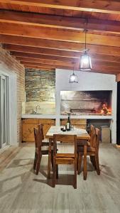 ein Esszimmer mit Tisch und Stühlen und einem Kamin in der Unterkunft Villa Yacanto Cabaña Inti Puka in Villa Yacanto