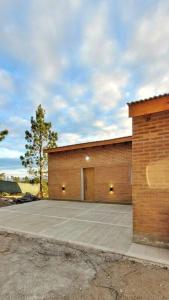 ein Backsteingebäude mit einer Seitentür in der Unterkunft Villa Yacanto Cabaña Inti Puka in Villa Yacanto + 21 Fotos