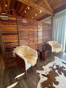 uma sala de estar com duas cadeiras e um tapete em Pousada Chalés Por do Sol em Campos de Jordão