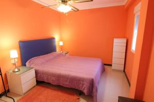 sypialnia z pomarańczowymi ścianami, łóżkiem i sufitem w obiekcie Vacansis,com Cabañal w mieście Cullera