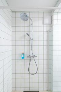 um chuveiro na casa de banho com azulejos brancos em Mautern Oasis / 50m² / Comfortable with Terrace em Mautern