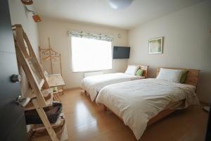 Zimmer mit 2 Betten und einem Fenster in der Unterkunft Santari in Shintoku