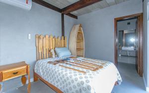 a bedroom with a bed with a wooden head board at Refúgio da Arara in São Sebastião +11 photos