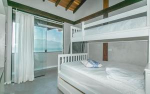 a bedroom with two bunk beds and a window at Refúgio da Arara in São Sebastião