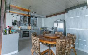 a kitchen with a wooden table and chairs at Refúgio da Arara in São Sebastião