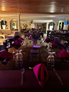 ein Esszimmer mit einem Tisch mit lila Servietten in der Unterkunft Di Carbone Hotel Gastrobar in Facatativá