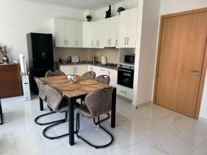 a kitchen with a wooden table and chairs in a room at NEW Luxury Condo - In the heart of Santa Maria in Santa Maria