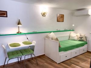 a small room with a green bench and a table at Apartments Padre **** in Baška