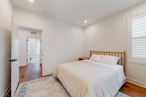 a white bedroom with a bed and a window at Marlin Chase---30453 Madeira Ln in Ocean View