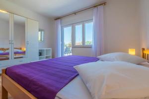 ein Schlafzimmer mit einem großen Bett mit einer lila Decke in der Unterkunft Apartment Silvana in Dramalj