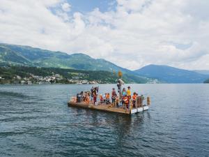 Un groupe de personnes sur une barge sur un lac dans l'établissement Familienhotel Post, à Millstatt