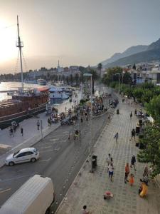 eine Gruppe von Menschen, die auf einer Straße in der Nähe des Wassers spazieren gehen in der Unterkunft Apartment Port in Makarska + 2 Fotos