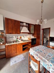 une cuisine avec des placards en bois et une table avec une nappe dans l'établissement Margherita 64, à Pescara