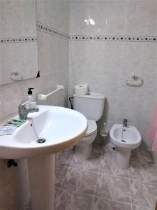 a bathroom with a white sink and a toilet at Habitaciones de Hostal a Primera linea de playa en Cullera in Cullera