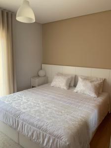 una camera con un letto bianco con due cuscini di Casa Vilarelho a Caminha