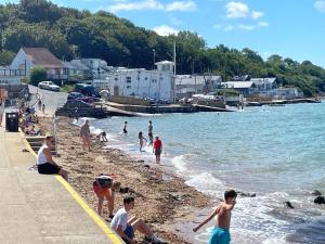 a group of people on a beach near the water at No 28 cosy cottage in the heart of Cowes in Cowes