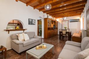 a living room with two couches and a table at Rena's house Corfu in Ágios Márkos