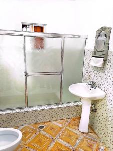 a bathroom with a glass shower and a sink at Bchome hostal in Boca Chica