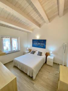 Schlafzimmer mit einem großen weißen Bett und Holzböden in der Unterkunft Appartamento in centro paese in Monterosi