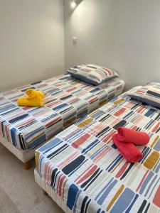 two beds with towels on them in a room at La maison du Soleil in Porticcio