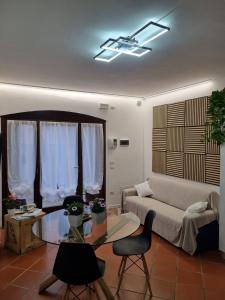 ein Wohnzimmer mit einem Sofa und einem Glastisch in der Unterkunft Villa Trevisi - APARTMENT in Treviso