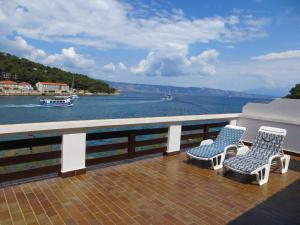 a balcony with two chairs and a view of the water at Apartments Makjanić in Jelsa